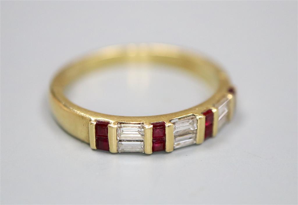 A modern 18ct gold, square cut ruby and baguette cut diamond set half hoop ring, size Q, gross 3.6 grams.